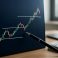 Close-up of a trading chart on a screen with highlighted support and resistance levels and a pen pointing at the chart.